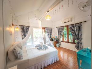 a bedroom with a white bed with a window at Baan Kiao in Haad Yao +147 photos