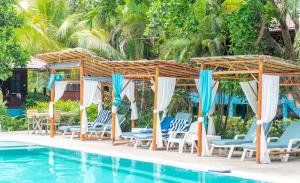 a group of chairs and umbrellas next to a swimming pool at Baan Kiao in Haad Yao