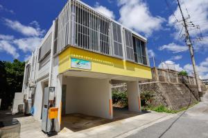 a yellow and white building with a balcony at 栞-shiori-NAKASONE in Miyako-jima