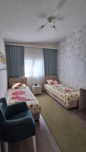 a bedroom with two beds and a chair in it at Dubrava 112 in Dobra Voda