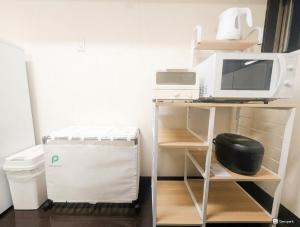 a desk with a computer and a microwave on it at Shiokaze Miura Kaigan - 三浦海岸 in Miura