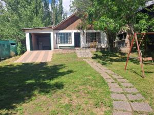 a house with a yard with a swing at Casa de montaña, valle del sol, potrerillos, Mendoza in Villa Bastía