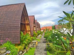 a row of houses in a garden at Bataran Garden Cottage in Nusa Penida