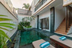 a swimming pool in the middle of a house at Villa Raka by Manara in Legian