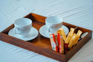 a tray with two cups and plates and pencils at Tranquil Heaven Near Galle & Unawatuna Quiet Stay & Fast WiFi in Galle