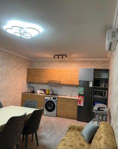 a kitchen with a couch and a table and a refrigerator at Rewad villa in Gabala