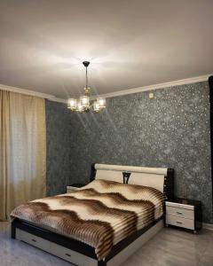 a bedroom with a bed and a chandelier at Rewad villa in Gabala