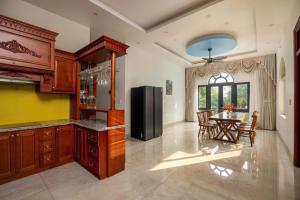 a kitchen with a refrigerator and a table with chairs at Sunstone Villa in Trung Gia