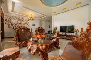 a living room with a table and a tv at Sunstone Villa in Trung Gia