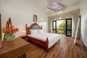 a bedroom with a bed and a large window at Sunstone Villa in Trung Gia +17 photos