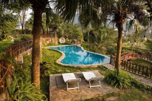 a swimming pool with two chairs and a table at Sunstone Villa in Trung Gia
