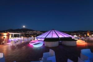 a marquee with white tables and chairs at night at Hotel Granada Palace, Affiliated by Melia in Monachil