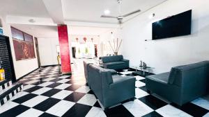 a lobby with two chairs and a television on a checkered floor at Hotel Beijing Cartagena in Cartagena de Indias