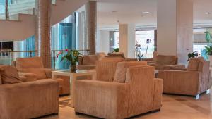 a waiting room with brown chairs and tables at Hotel Granada Palace, Affiliated by Melia in Monachil