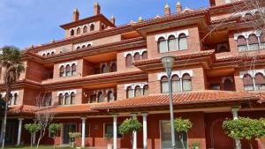 a large red brick building with a lot of windows at Hotel Granada Palace, Affiliated by Melia in Monachil