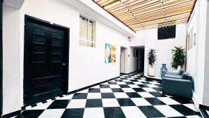 a hallway with a black door and a checkered floor at Hotel Beijing Cartagena in Cartagena de Indias
