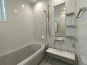 a bathroom with a tub and a sink and a mirror at マークヴィラスイート in Shimo-suwa +13 photos