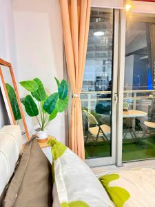 a room with a window with a potted plant at Affordable Staycation at Azure Urban Resort Residences Near NAIA in Manila +18 photos