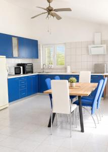 a kitchen with blue cabinets and a wooden table and chairs at Family and pet friendly apartment Frankopan Croatia in Šmrika