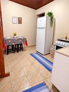 a kitchen with a white refrigerator and a table at Cantinho aconchego 2 in Naviraí +5 photos