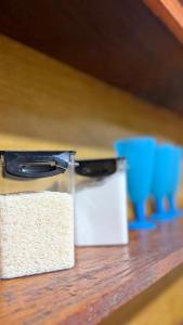 two containers of rice sitting on a wooden shelf at Cantinho aconchego 2 in Naviraí