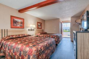 a hotel room with two beds and a television at Redmond Inn in Redmond