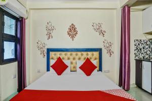 a bedroom with a large bed with red pillows at Super Hotel O Shankar Hotel Ghaziabad Railway Station in Ghaziabad