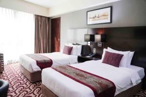 a hotel room with two beds and a window at Ming Garden Hotel in Kota Kinabalu