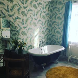 a bathroom with a claw foot tub and wallpaper at Newberry Beach lodge in Combe Martin +88 photos