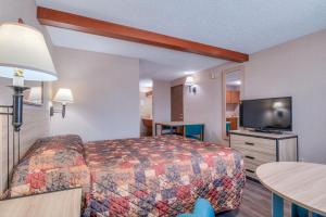 a hotel room with a bed and a flat screen tv at Redmond Inn in Redmond