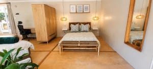 a bedroom with a bed and a mirror and a desk at Joy Haven - Open Plan Studio in Centurion +17 photos