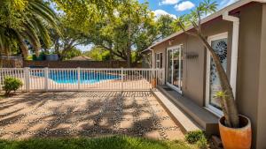 a house with a pool and a fence at Joy Haven - Open Plan Studio in Centurion