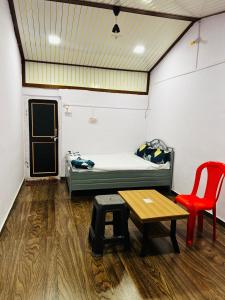 a room with a bed and a table and a chair at Lake breeze homestay in Shendi