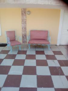 two chairs sitting on top of a checkered floor at Belle maison bord de mer rdc in El Haouaria +4 photos