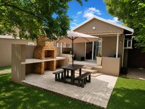a patio with a table and benches in front of a house at Joy Haven - Cottage in Centurion