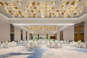 a ballroom with white chairs and a chandelier at Sheraton Grand Beijing Dongcheng Hotel in Beijing +89 photos