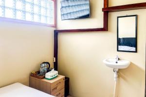 a bathroom with a sink and a mirror at Kings Hotel Dieng RedPartner in Diyeng