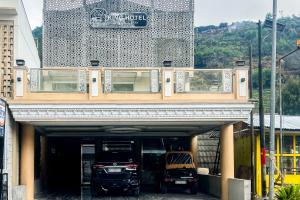 a building with two cars parked in a garage at Kings Hotel Dieng RedPartner in Diyeng