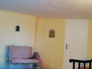 a chair in a room with a yellow wall at Belle maison bord de mer rdc in El Haouaria