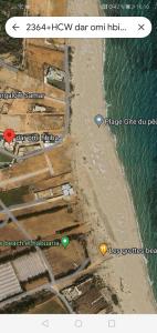 a view of a beach and the ocean with two icons at Belle maison bord de mer rdc in El Haouaria
