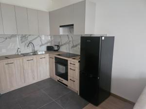 a kitchen with a black refrigerator and wooden cabinets at Apartament Centrum in Giby