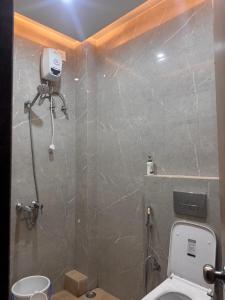 a bathroom with a shower and a toilet in it at Sunita Kunj in Jhūsi