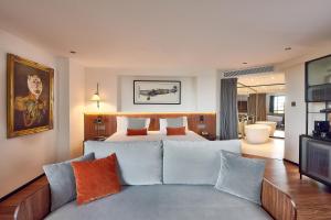 a bedroom with a bed and a couch and a television at Meliá White House in London