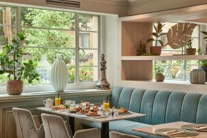 a dining room with a table and chairs and windows at Meliá White House in London