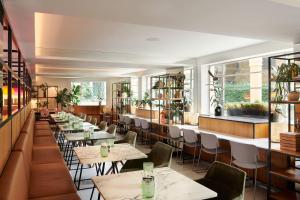 a restaurant with tables and chairs and windows at Meliá White House in London +124 photos
