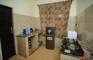 a small kitchen with a stove and a refrigerator at Panofu Homestay in Moshi