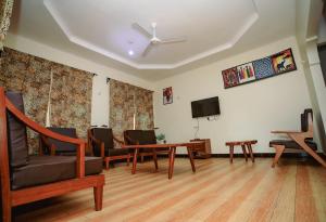 a living room with a table and chairs and a tv at Panofu Homestay in Moshi