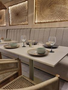 a table with plates and wine glasses on it at Casa Tayrona Suites in Medellín