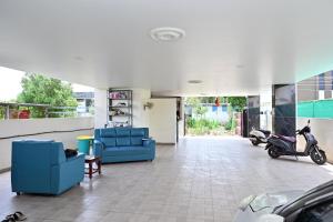 a living room with two blue chairs and a scooter at Hotel Siddveer Grand in Guntūr