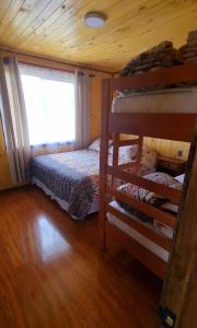 a bedroom with two bunk beds and a window at Cabañas Chiloé in Dalcahue